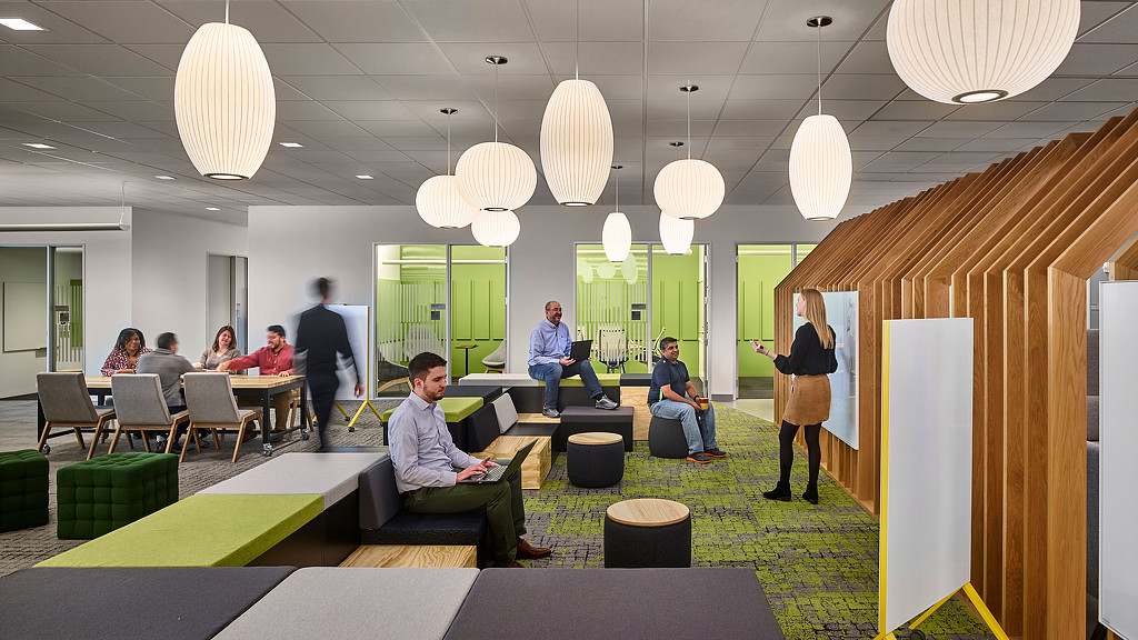 A group of people sitting in a room with chandeliers.